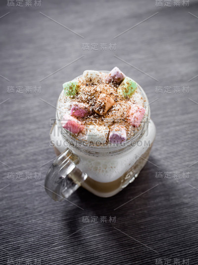 背景是一杯彩色棉花糖卡布奇诺。美味的饮料