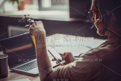后视图的自由职业者持有手机在他的手。