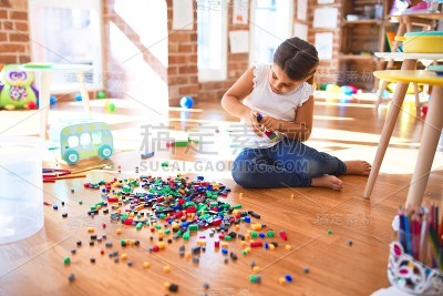 可爱的幼童玩积木玩具周围的许多玩具在幼儿园
