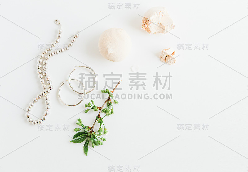 女性饰品，棉花糖和绿色的树枝在白色的背景。美容博客的概念。为杂志和社交媒体。女人的时尚珠宝。平的。