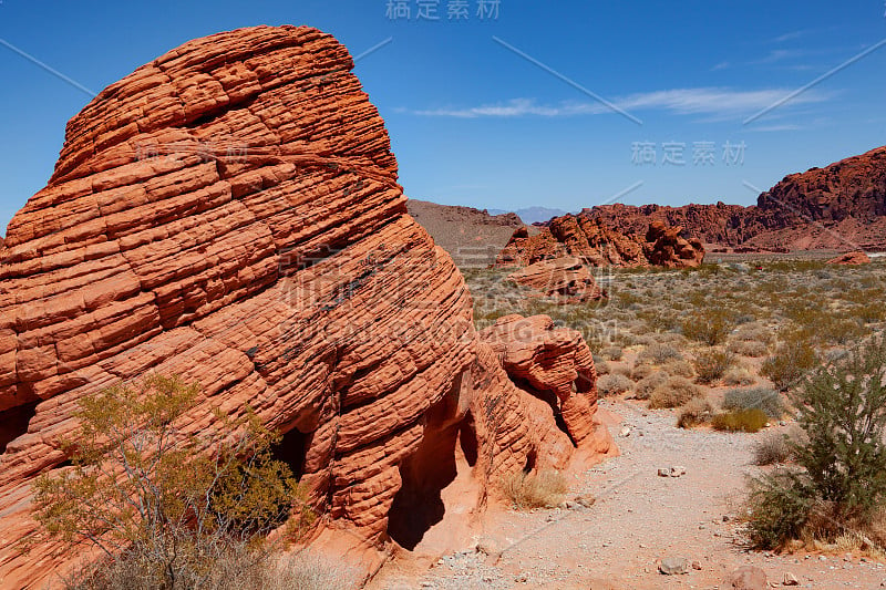 红色的岩层在前景，灌木丛和岩石在背景内的国家火谷公园，内华达州