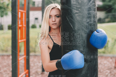 美丽性感的女战士摆姿势与沙袋