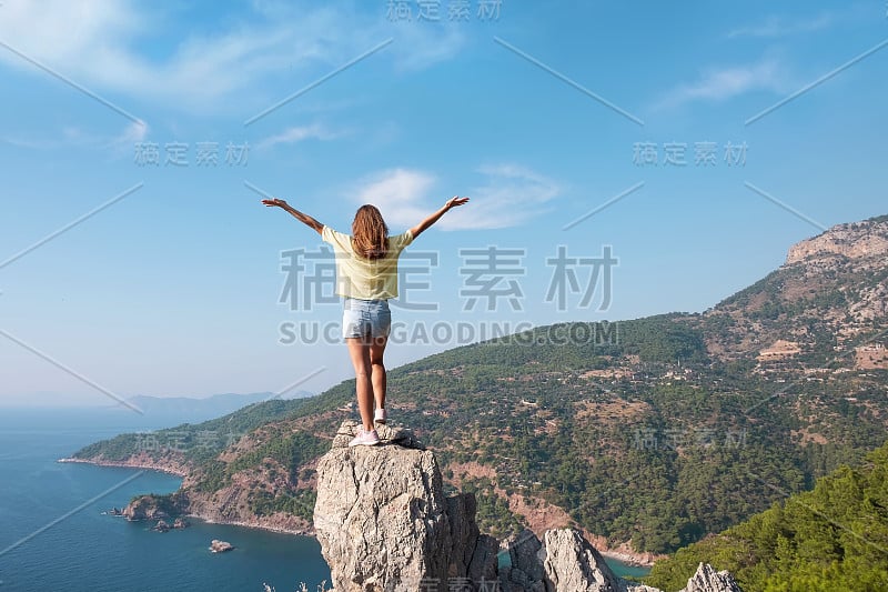 土耳其Oludeniz卡巴克海滩，山顶上的徒步女孩，自由的概念，胜利，积极的生活方式