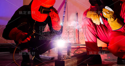 男性焊工在现场一起工作。