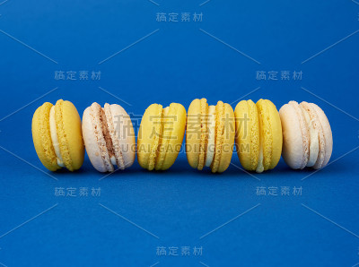 一堆五颜六色的圆马卡龙蛋糕，在深蓝色的背景上