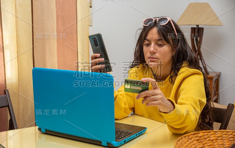 年轻女孩拿着信用卡用智能手机购物。网上购物的概念