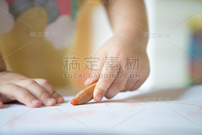 2岁孩子近距离用彩笔在纸上画线。
