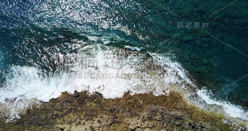 航道。海浪冲击着纯净的岩石海岸。无人机视角。清澈的蓝色清澈的水