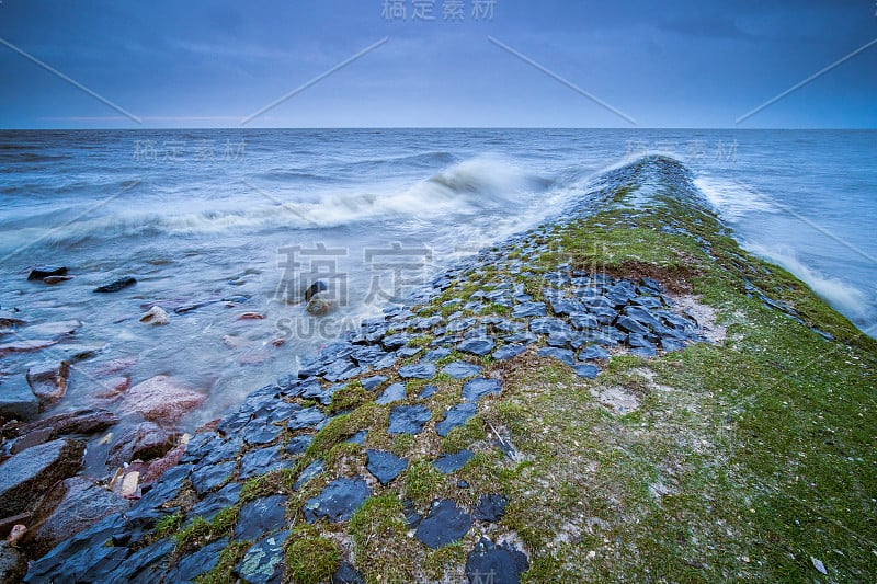 有暴风雨的天气，湖面上有乌云，海岸线上有暴风雨的波涛