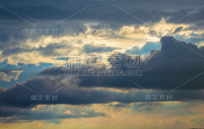 阳光普照的暴风雨天空。灿烂的日落与雨云。