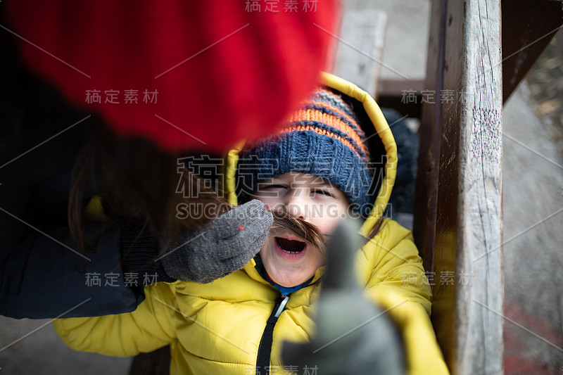 年轻的母亲玩她儿子的股票照片