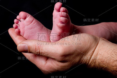 父亲抱着婴儿的脚