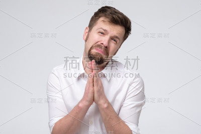 情绪化的家伙握紧双手，皱着眉头乞求原谅