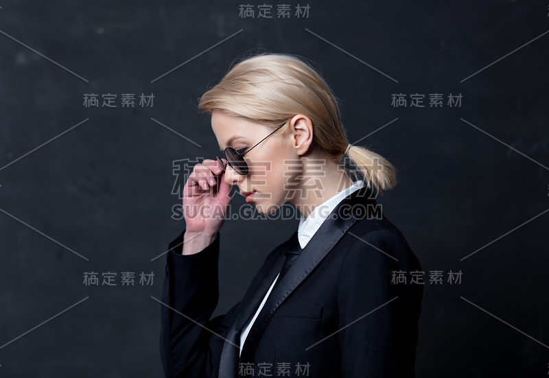 典型的女商人穿着黑色西装，戴着墨镜