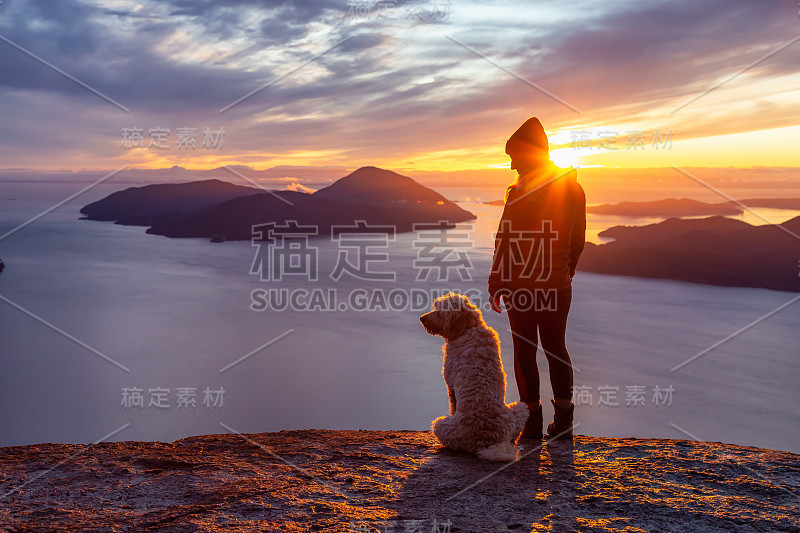 爱冒险的女孩带着狗在山顶徒步旅行