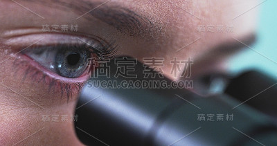 女人正在通过显微镜看东西