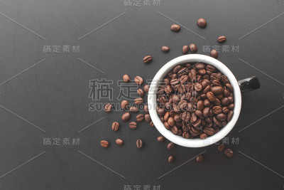 黑色背景的杯子里的咖啡豆