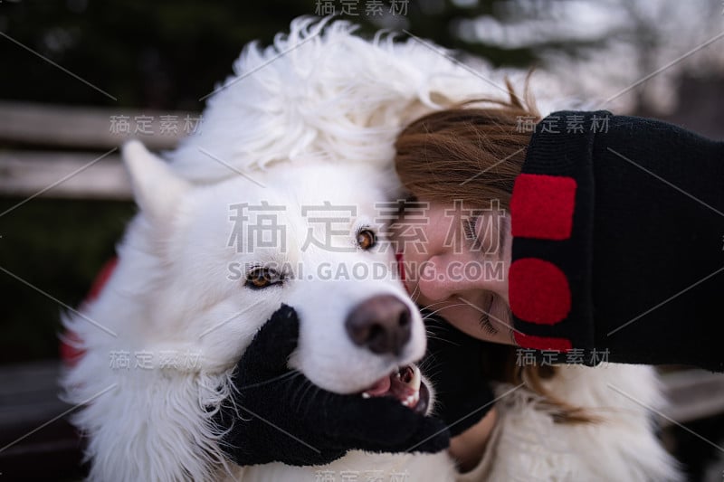 一个女孩亲吻她的宠物狗照片