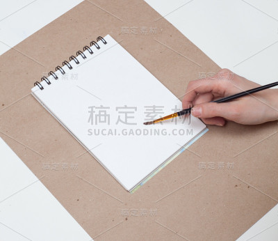 女人手绘在白色空白页的速写本