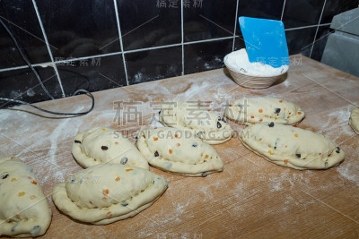圣诞蛋糕与葡萄干和蜜饯木瓜，生面团在面粉木桌上