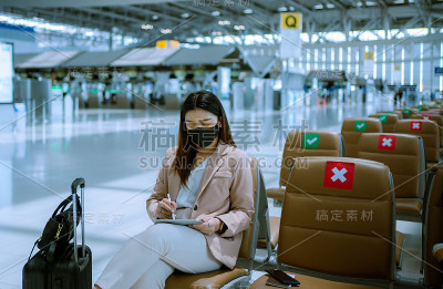亚洲商务女乘客在机场使用她的数字平板电脑。