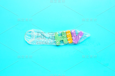 蓝色背景上印有“HIV”彩色字母的避孕套。