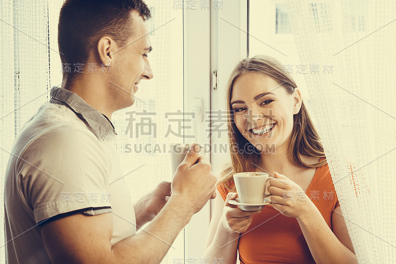 年轻夫妇在家里喝茶或喝咖啡