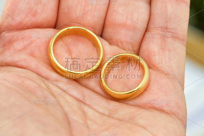 手里拿着两个结婚戒指