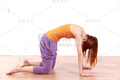 年轻女子做瑜伽“猫姿势”