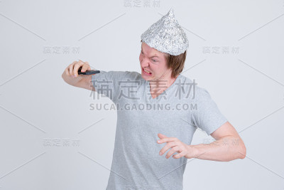 一名愤怒的年轻人拿着锡纸帽扔手机