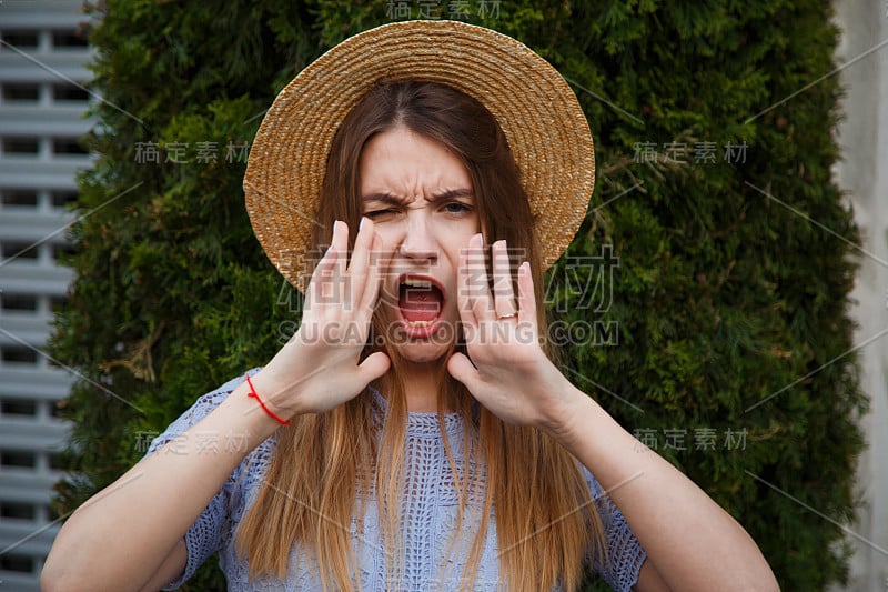 美丽的年轻女子在夏天的帽子大喊