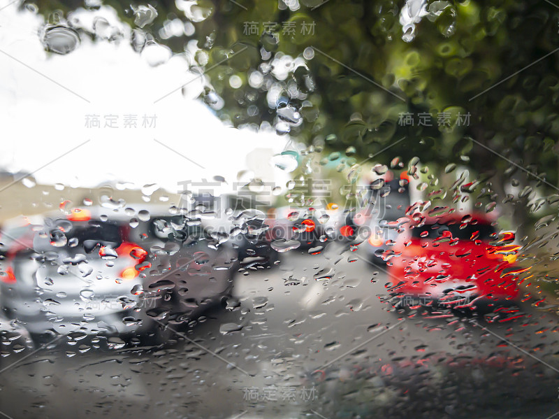 交通和雨水打在汽车玻璃上。