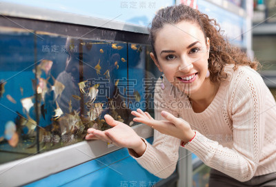 快乐积极的女孩看着热带鱼
