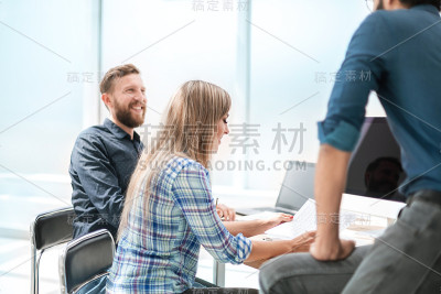年轻员工与同事讨论业务文件