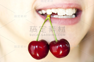 孩子的牙齿夹着樱桃