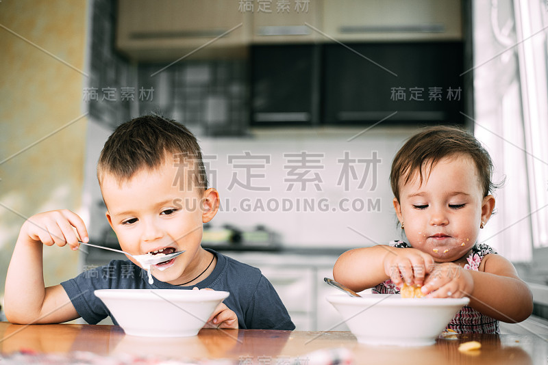 哥哥和妹妹白天在厨房里喝牛奶吃玉米片，非常有趣和可爱，肮脏和有趣