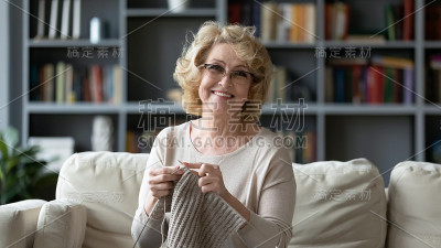 微笑的60多岁的奶奶喜欢在家编织