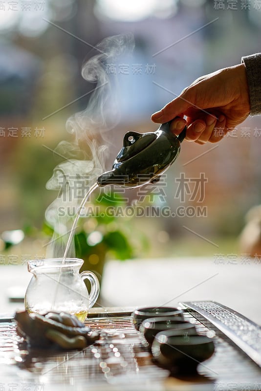 中国茶道。瓷壶和瓷杯，里面装着中国著名的蒸煮普洱茶。软的焦点。