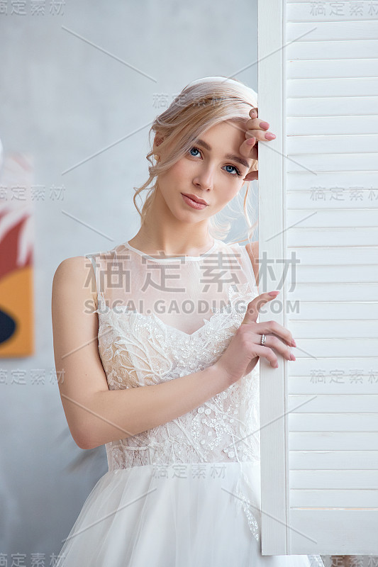 金发女孩穿着漂亮的白色婚纱。新娘在婚礼前等待新郎