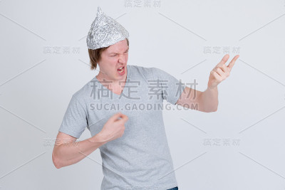 年轻人戴着锡箔帽和空气吉他手势