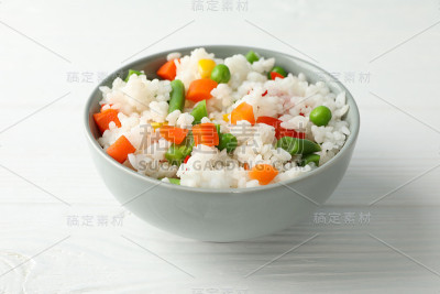 一碗美味的米饭和蔬菜在木制的背景上，特写