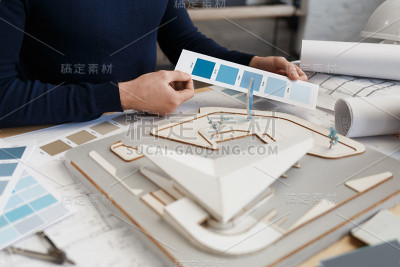 建筑师在办公室使用调色板工作。工程师使用色板为建筑选择颜色，为建筑项目寻找新的思路。英俊的胡子男人在