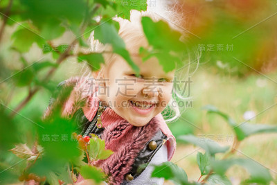 小女孩躲在树叶后面