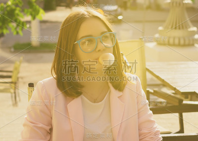 年轻漂亮的女孩在户外嚼口香糖