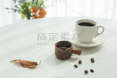 白色的咖啡杯和咖啡豆在白色的背景。