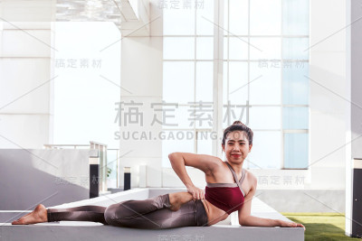 一个在大窗户前练习瑜伽的女人