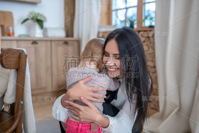 妈妈和女儿互相拥抱，微笑着