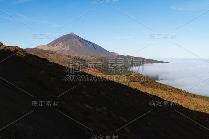 火山上方的云倒置沙漠景观，而日出