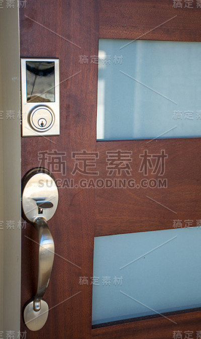 现代前门光滑的银色门把手和现代安全锁