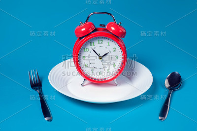 闹钟在白色板上的彩色背景。保健和食品概念